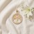Okrągły złoty wisiorek drzewko z listkami.jpg
